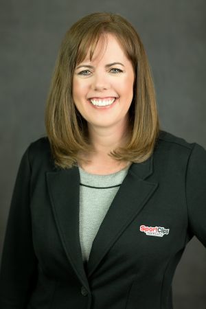 Headshot of franchisee Debra Sawyer in black coat with Sport Clips logo on left breast