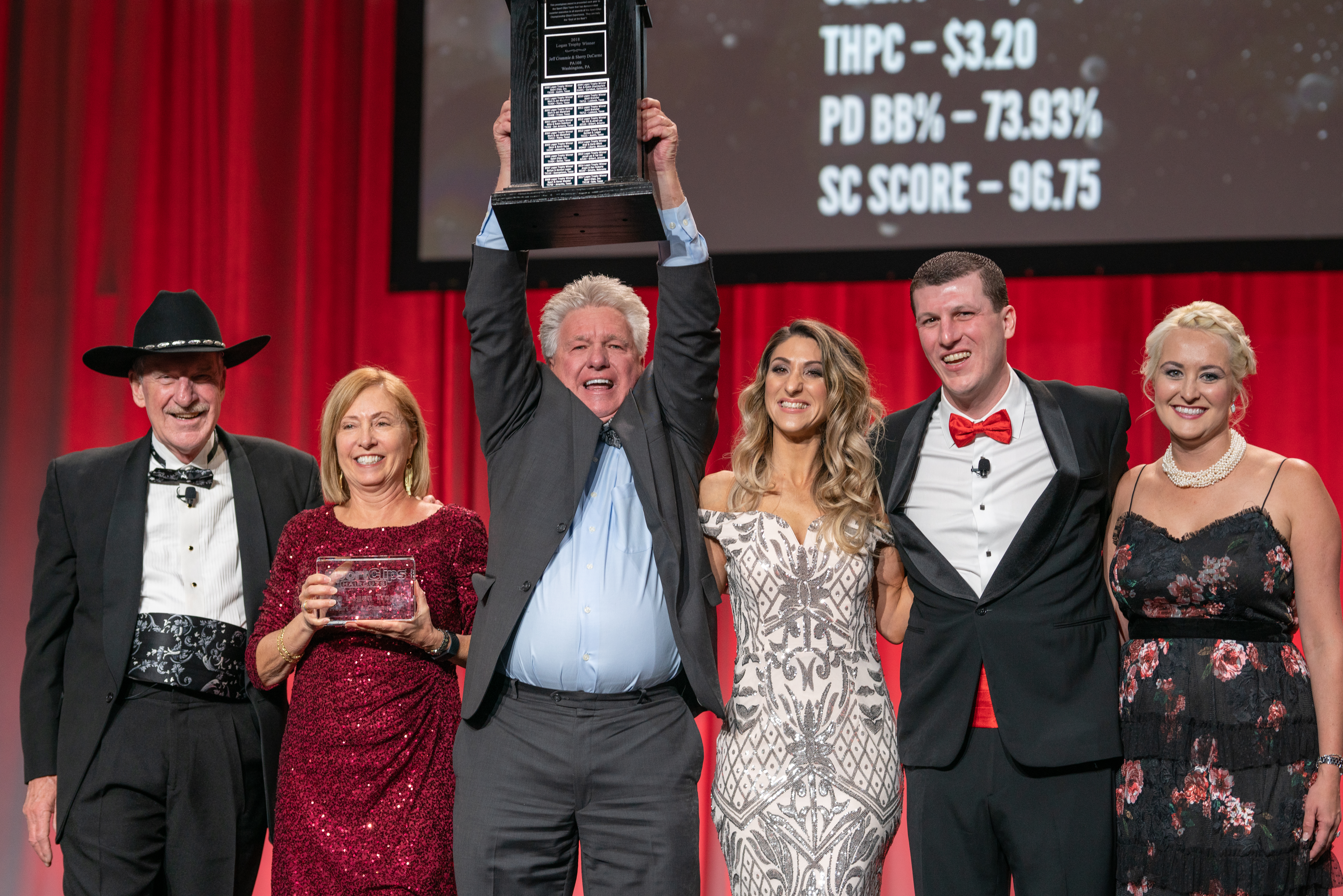 Team Leaders Jeffrey Crummie and Sherry DuCarme holding The Logan Trophy posing with Gordon Logan