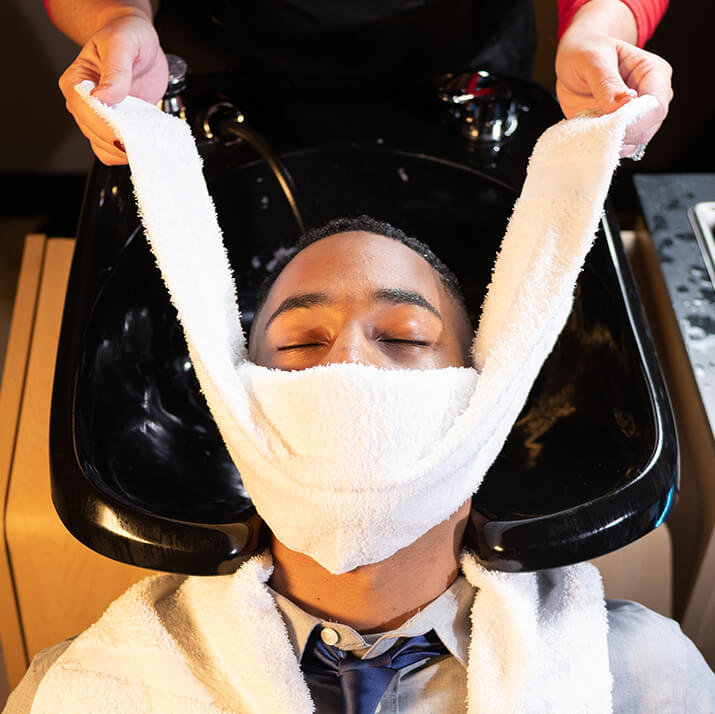 Hot towel being applied to face