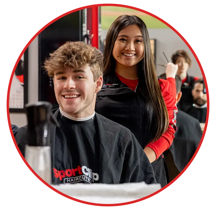 A stylist standing behind a Sport Clips customer
